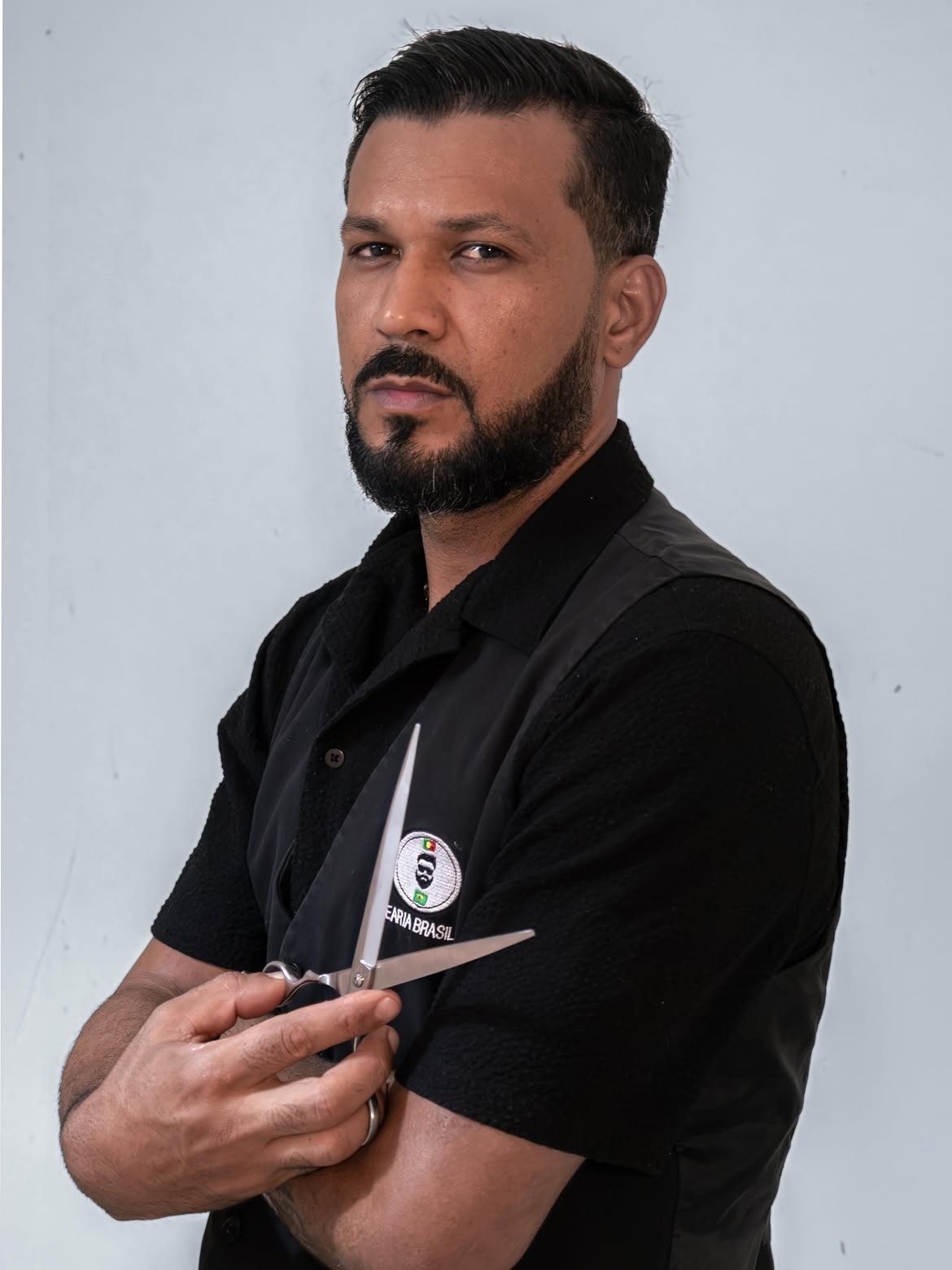 Retrato de barbeiro da Barbearia Brasileira segurando tesoura