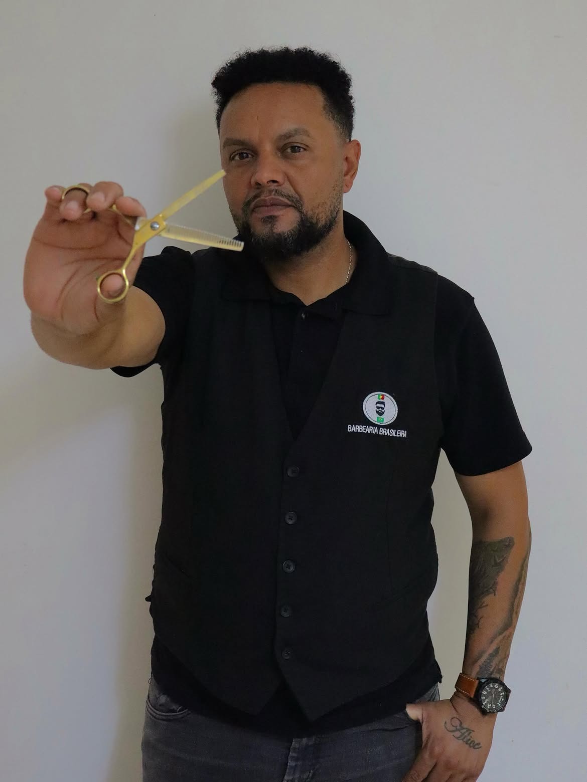 Retrato de barbeiro da Barbearia Brasileira segurando tesoura dourada